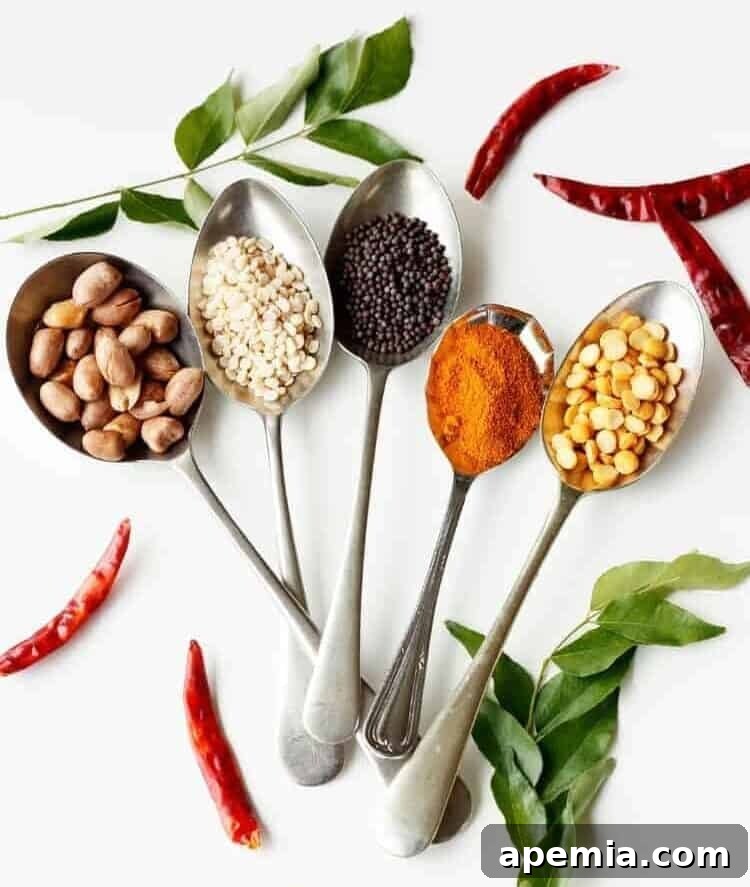 5 spoons, each holding a different whole Indian spice