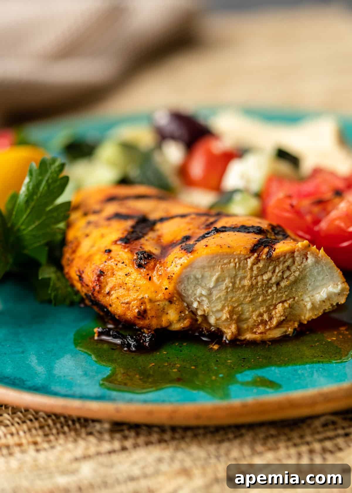 Close-up side view of a piece of saffron chicken cut in half, revealing its juicy, tender interior and perfectly cooked texture.