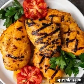 Plate of grilled saffron chicken with tomatoes and herbs, depicting the final dish.