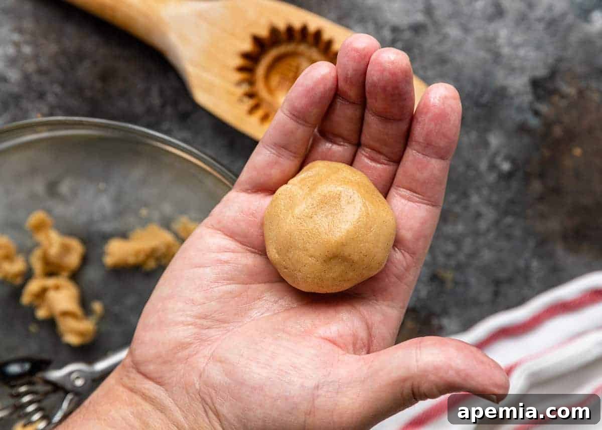 A scoop of delicate semolina cookie dough cradled in the palm of a hand, ready for shaping.