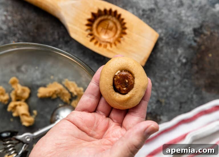 A date-filled maamoul cookie, prior to baking, showcasing its perfect shape and filling.