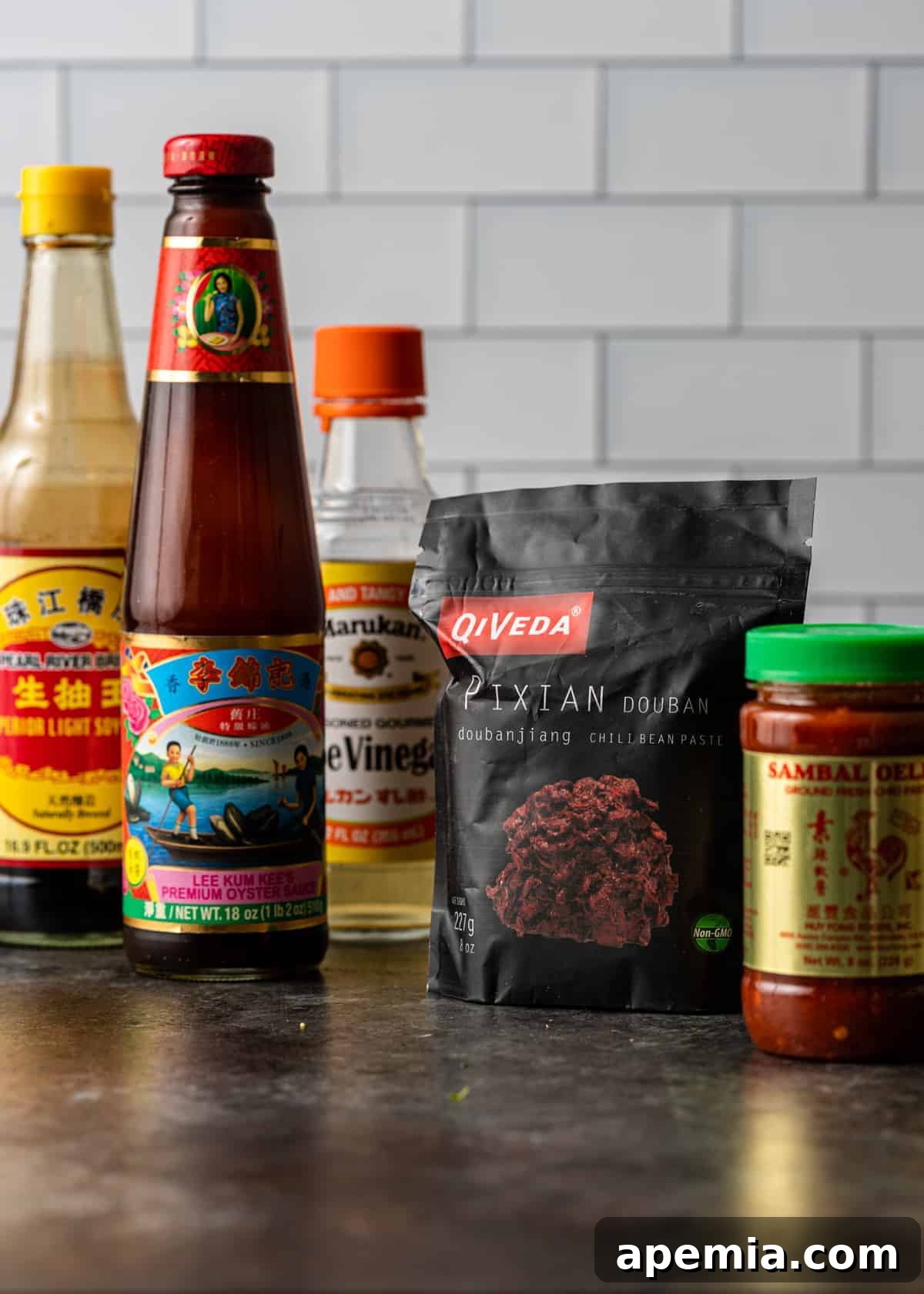 A collection of ingredient bottles arranged for making a spicy Hunan chicken recipe