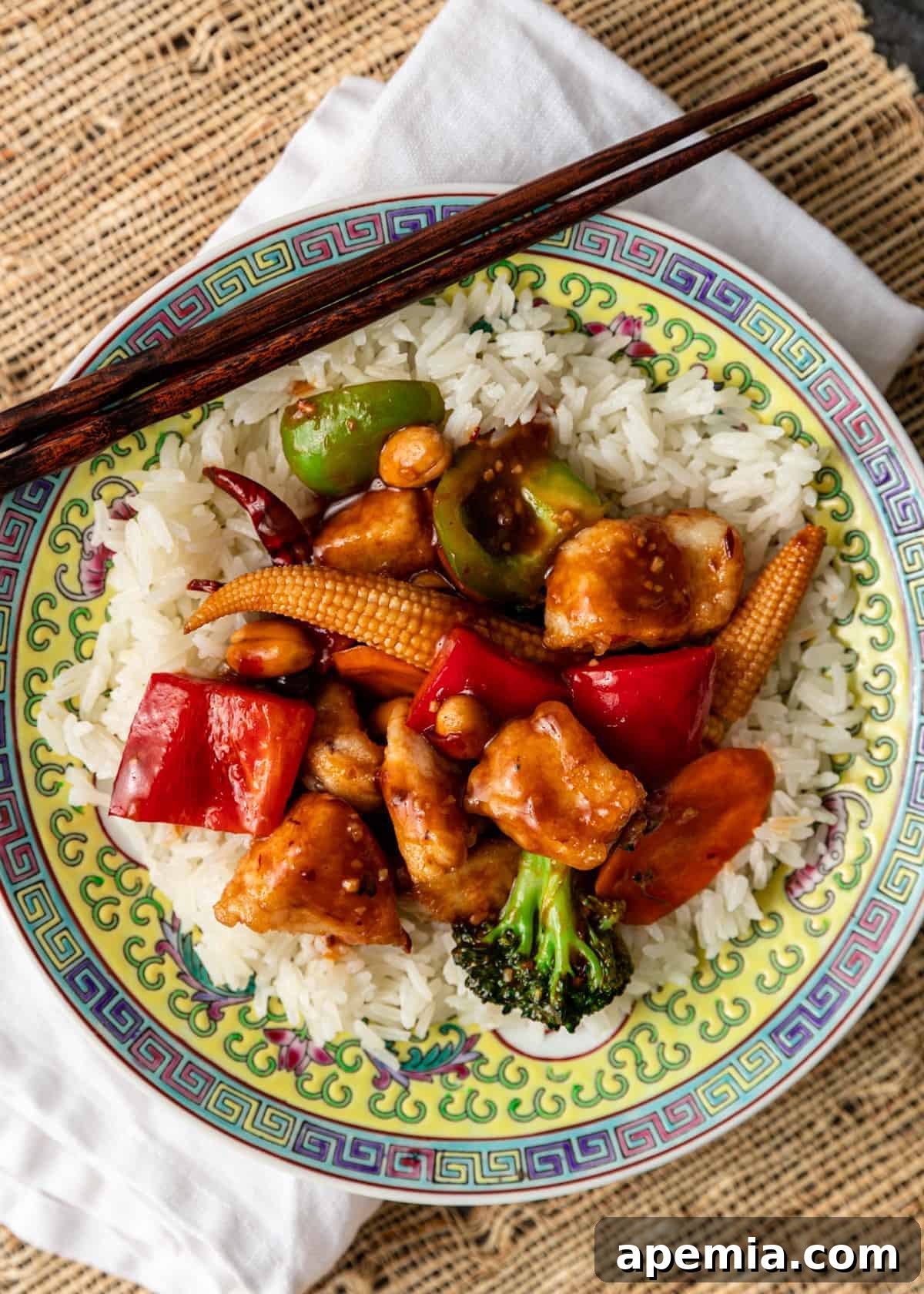 Overhead shot of a plate of Hunan chicken recipe served over white rice with chopsticks