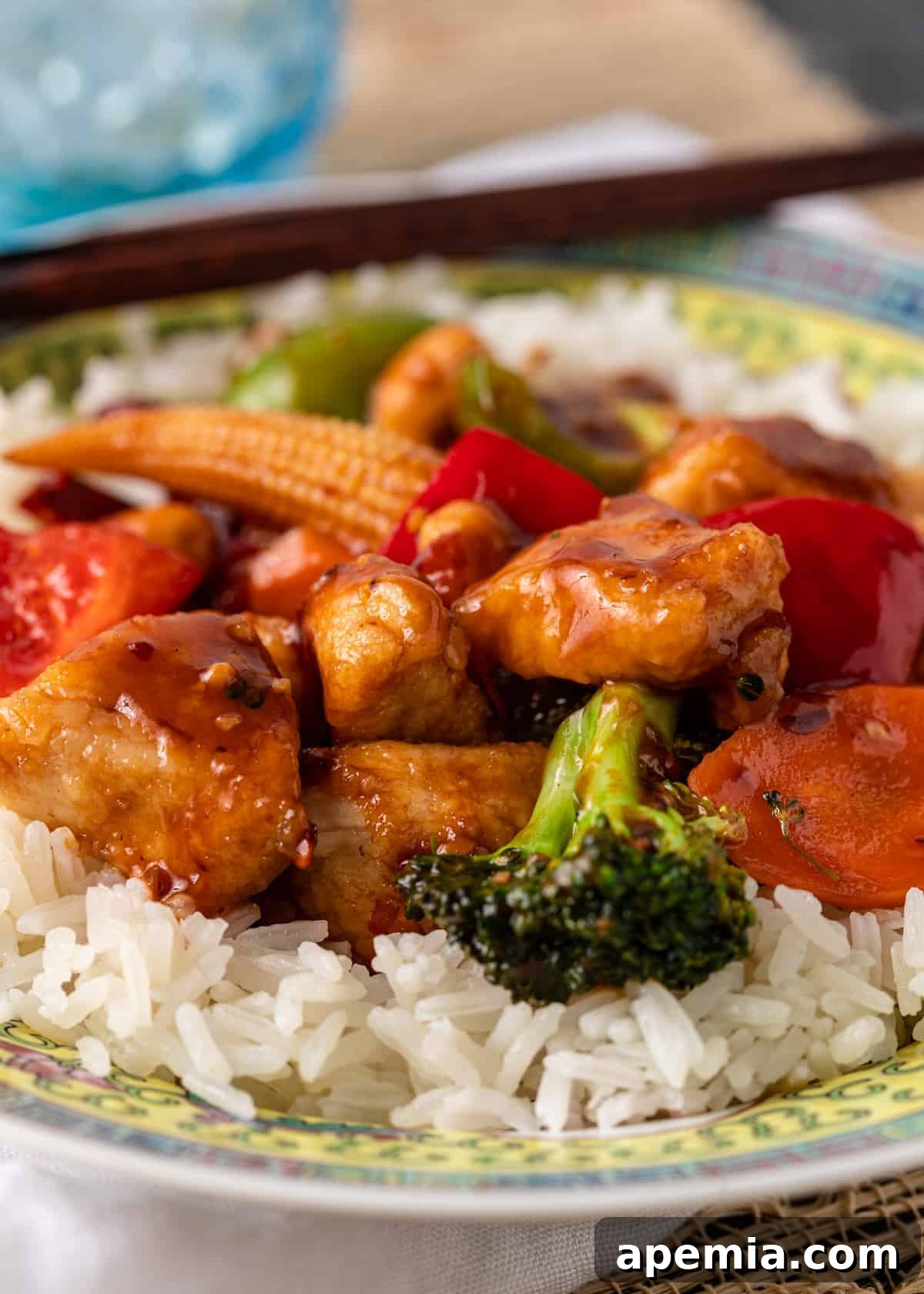 Closeup view of an easy Hunan chicken recipe served over white rice on a plate