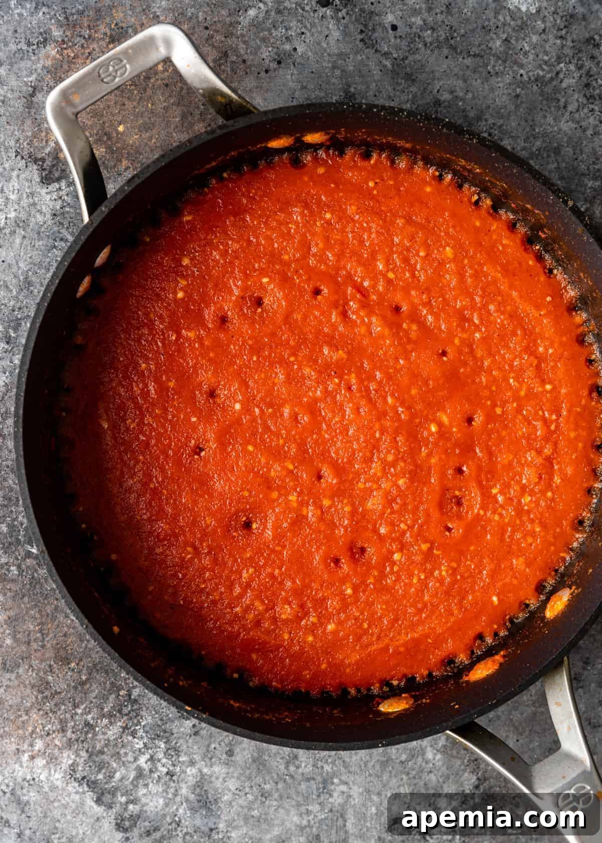 Overhead view of red sauce simmering in a skillet