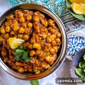 Overhead image of a bowl filled with chickpea curry, garnished for serving.