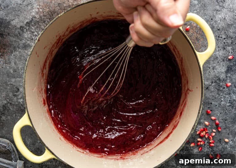 Whisking syrup into the pomegranate base until smooth for the Turkish Lokum recipe.