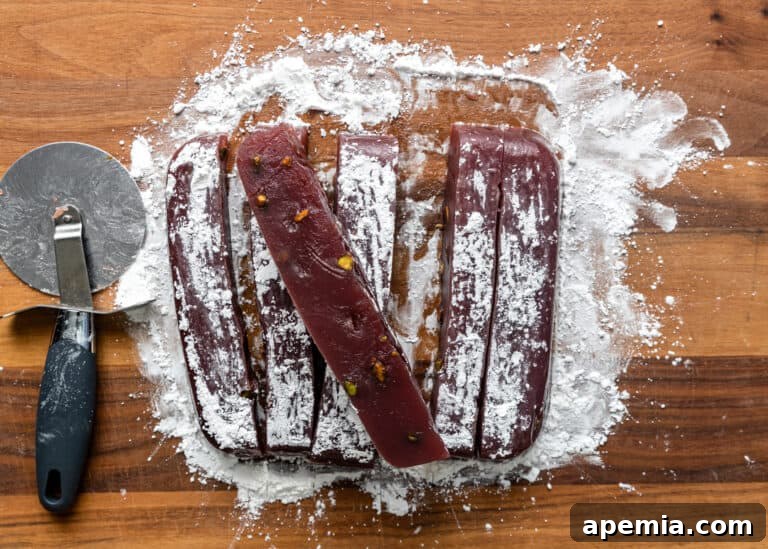 Slicing and cutting the overturned Turkish Delight into uniform pieces.