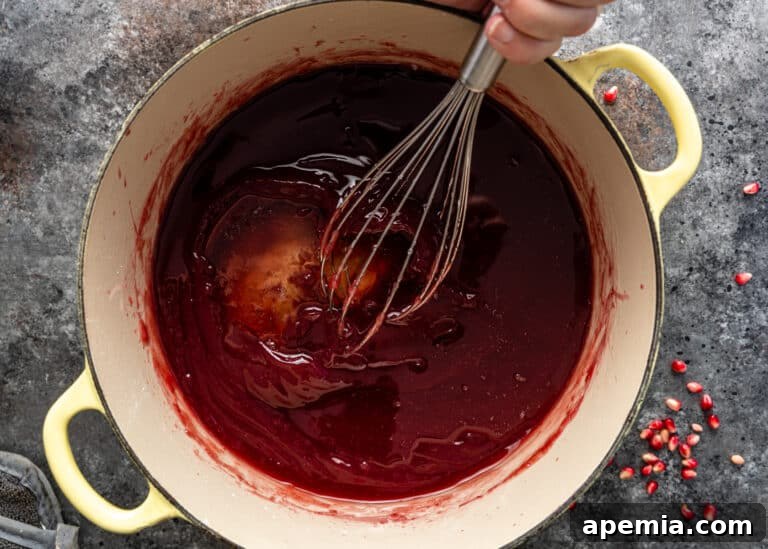 Whisking the initial amount of syrup into the pomegranate base for the Lokum recipe.