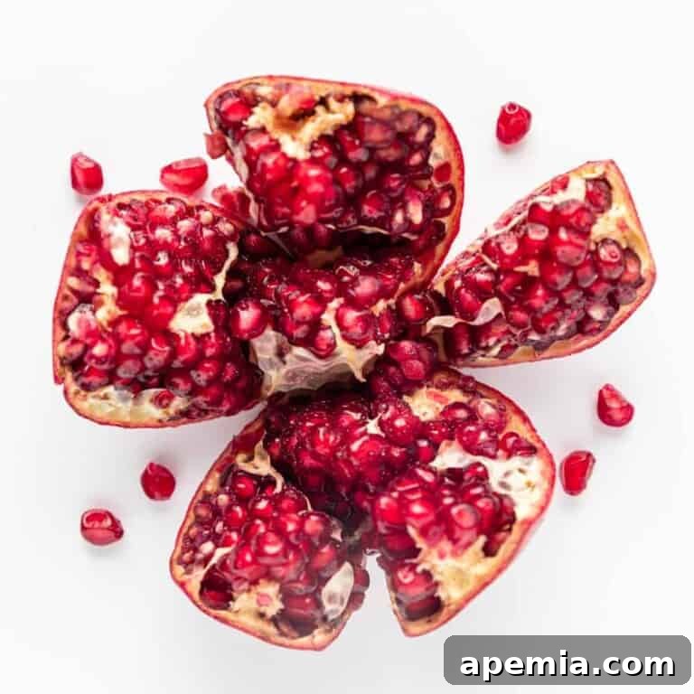 Overhead view of a pomegranate split open, revealing its glistening arils.