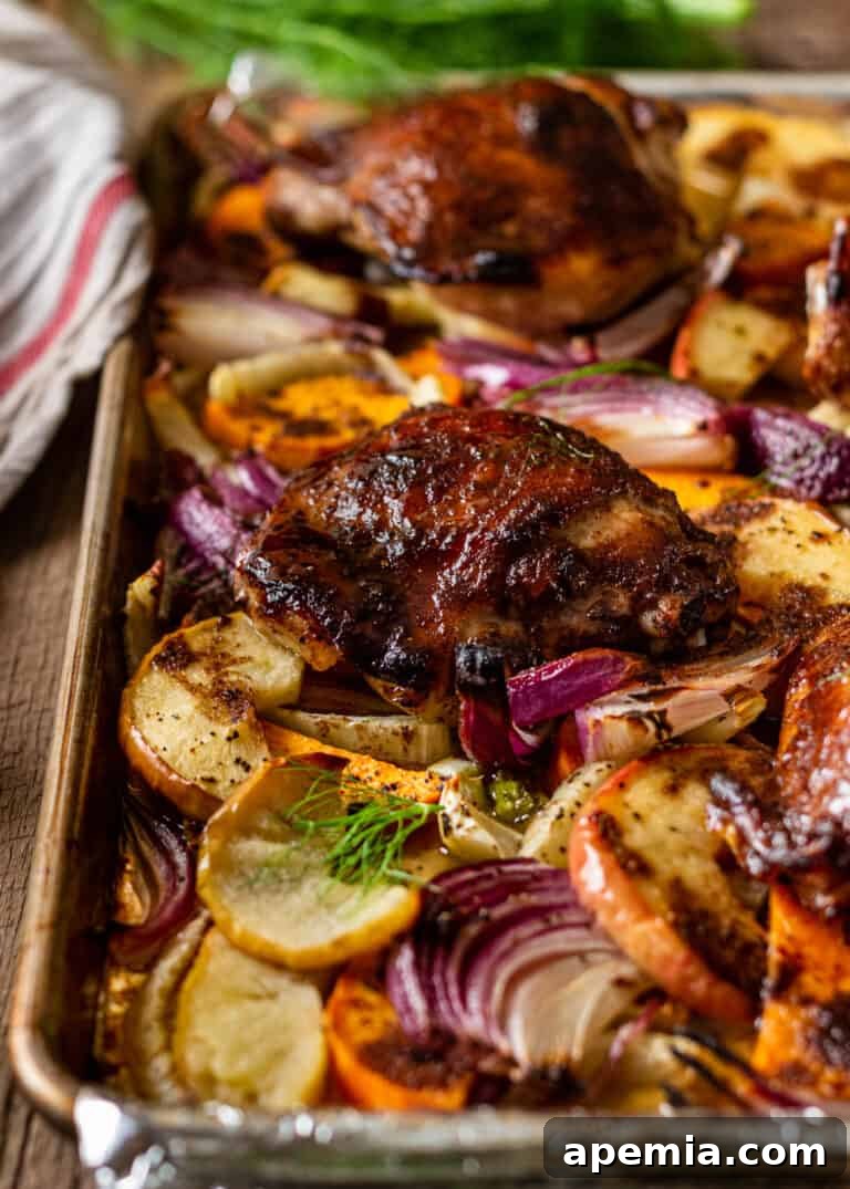 pieces of crispy skinned roast chicken and roasted vegetables on baking sheet