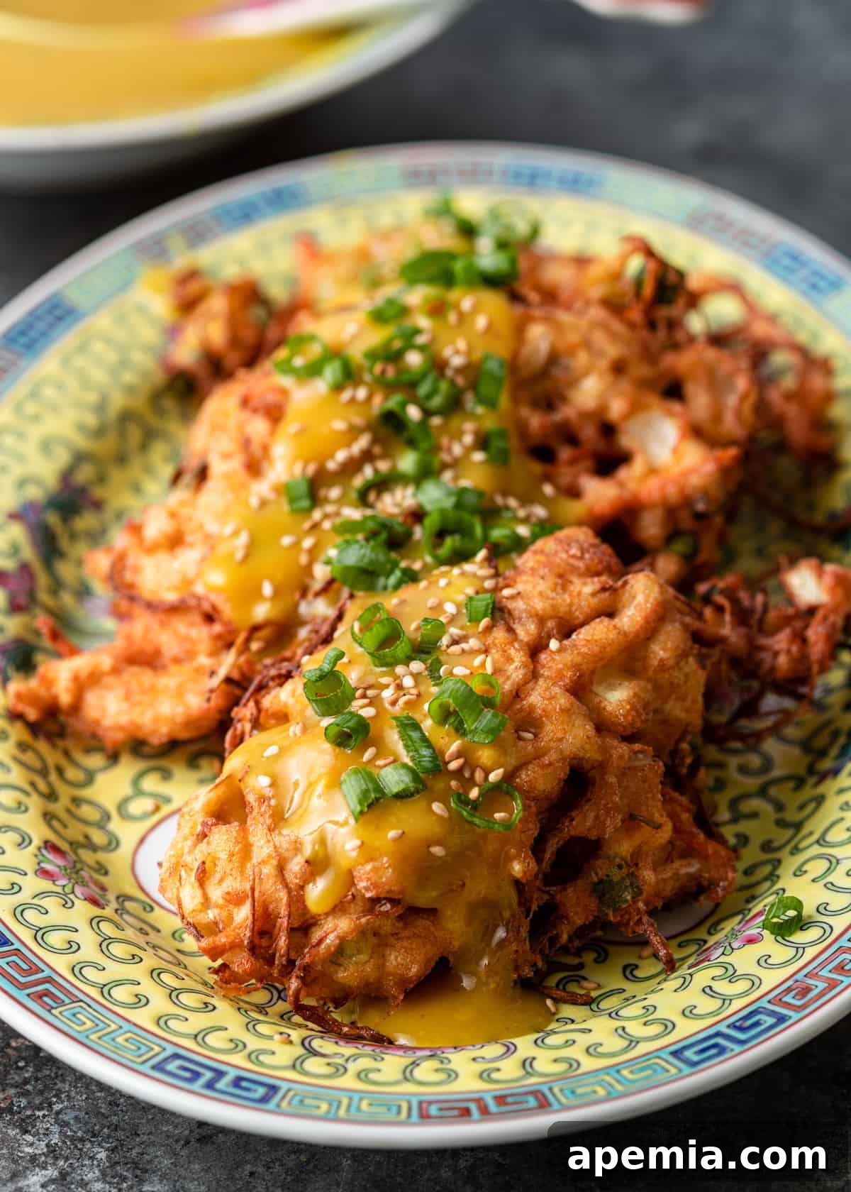 my egg foo young recipe on a platter with scallion and sesame seeds on top