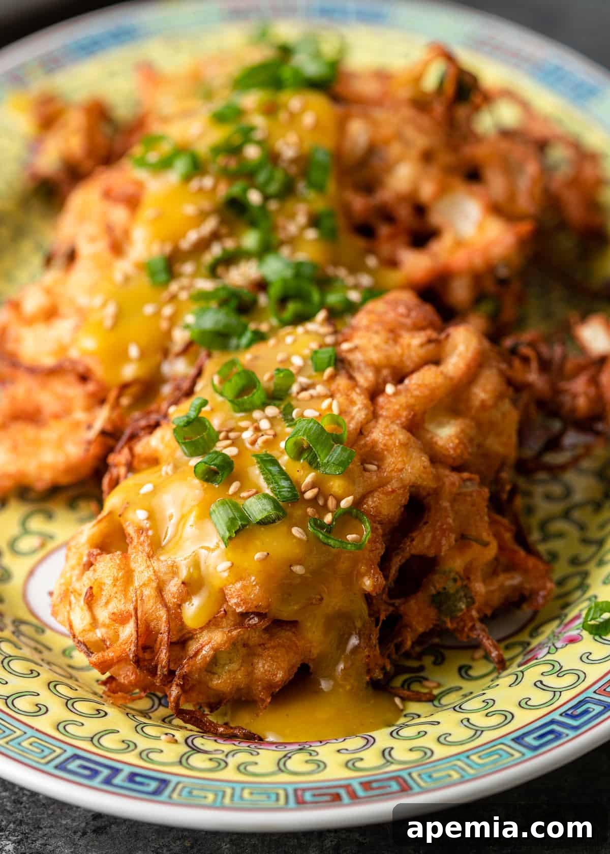 closeup: egg foo young with scallions on top on a ceramic platter