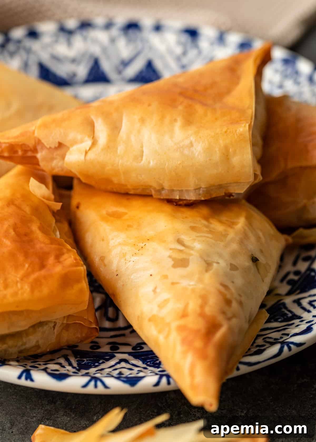 closeup: golden flaky phyllo spanakopita triangles