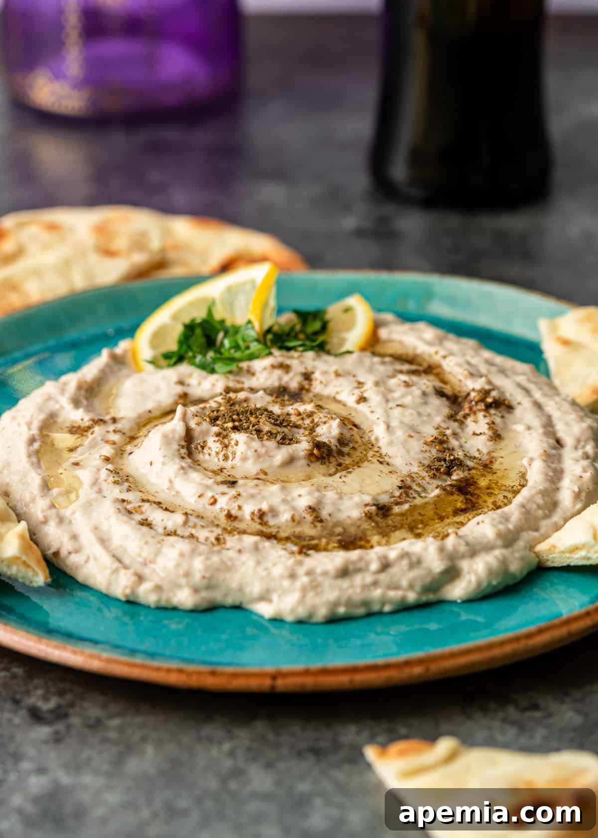 my white bean hummus recipe on blue plate with garnish of lemon slices