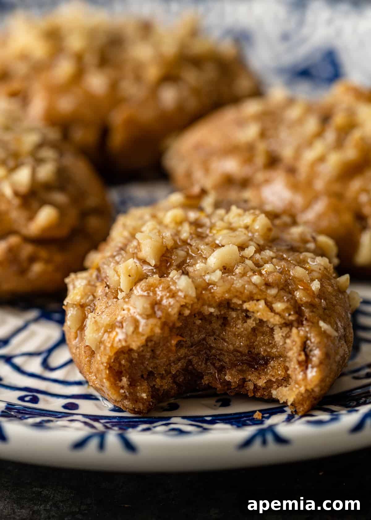 Closeup of a Greek Christmas cookie with a small bite taken out, revealing its moist interior