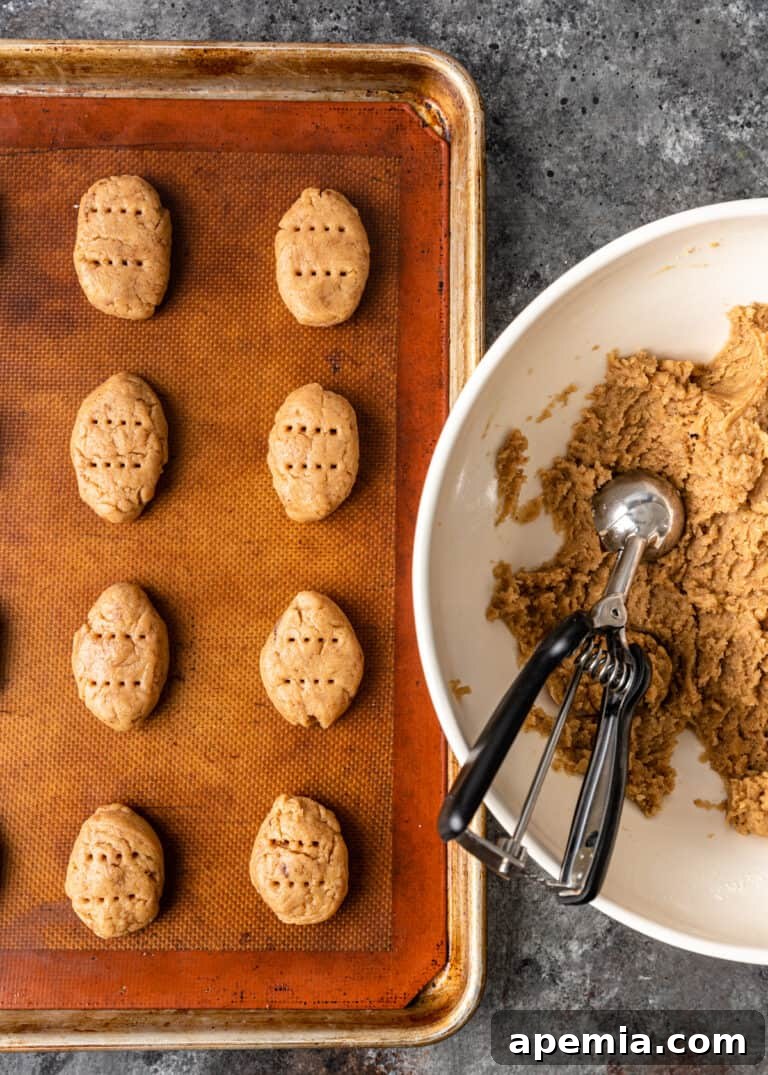Overhead shot of scooping Greek Christmas cookie dough from a bowl onto a baking pan