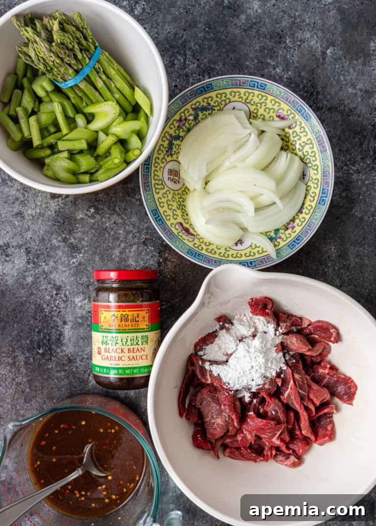Overhead view of bowls filled with prepped ingredients for my beef with black bean sauce recipe, demonstrating mise en place.