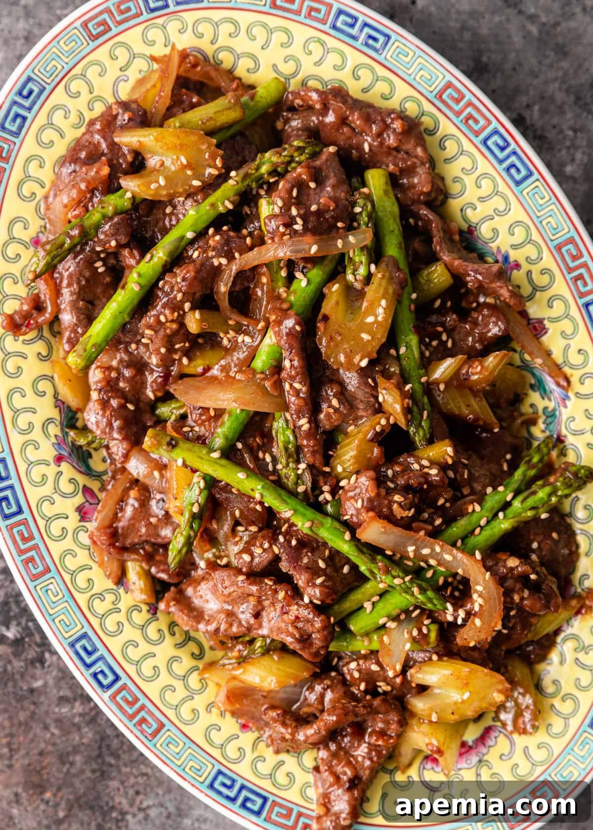 Overhead view of a beautifully arranged platter of beef with black bean sauce and assorted fresh vegetables, ready for serving.