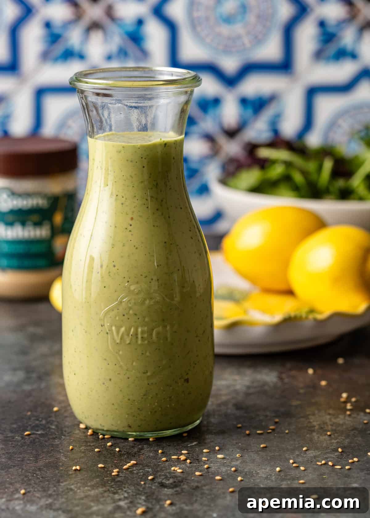 Closeup side view of a jar filled with freshly made lemon sesame dressing, ready for storage or serving, highlighting its inviting creamy texture.