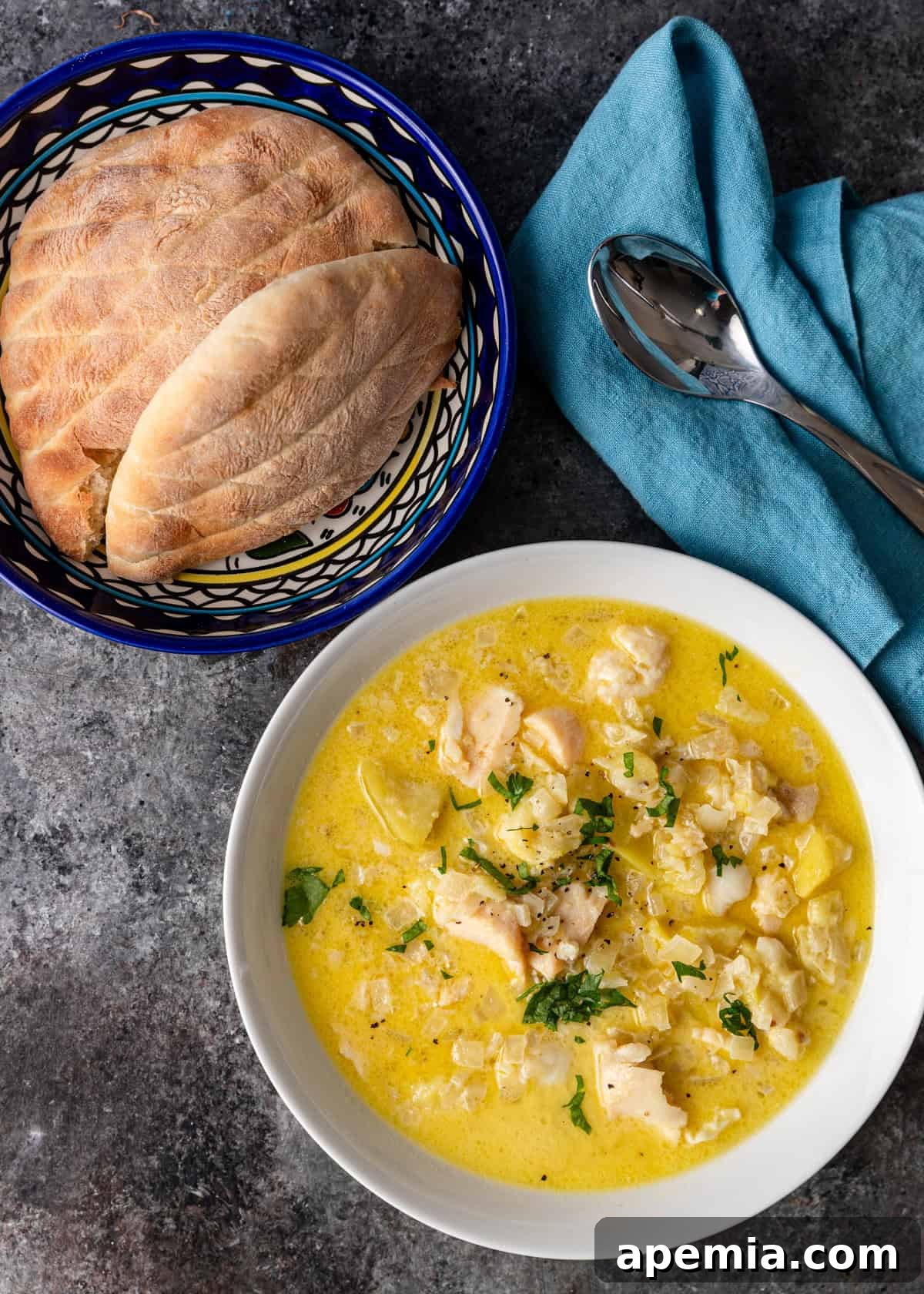 overhead: ready to serve bowl of Croatian cod stew with bowl of bread on side