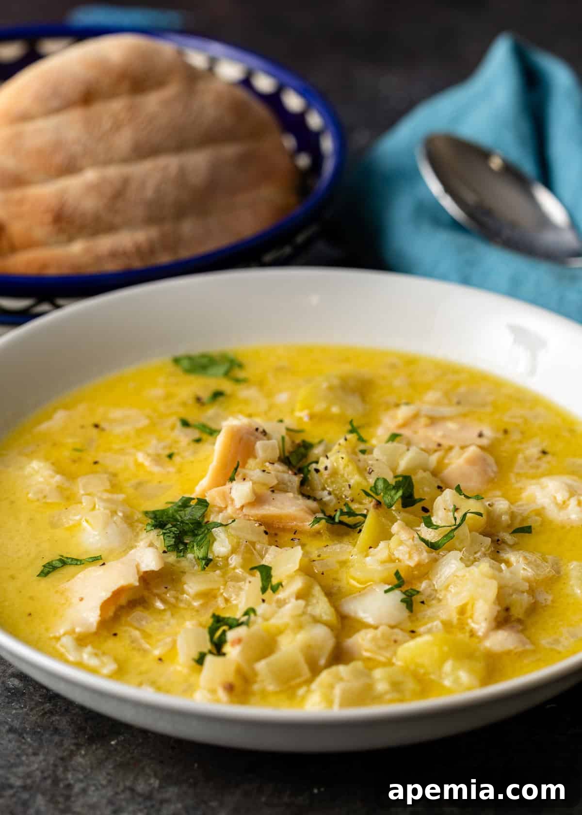 closeup side view: white bowl of bakalar with bowl of bread