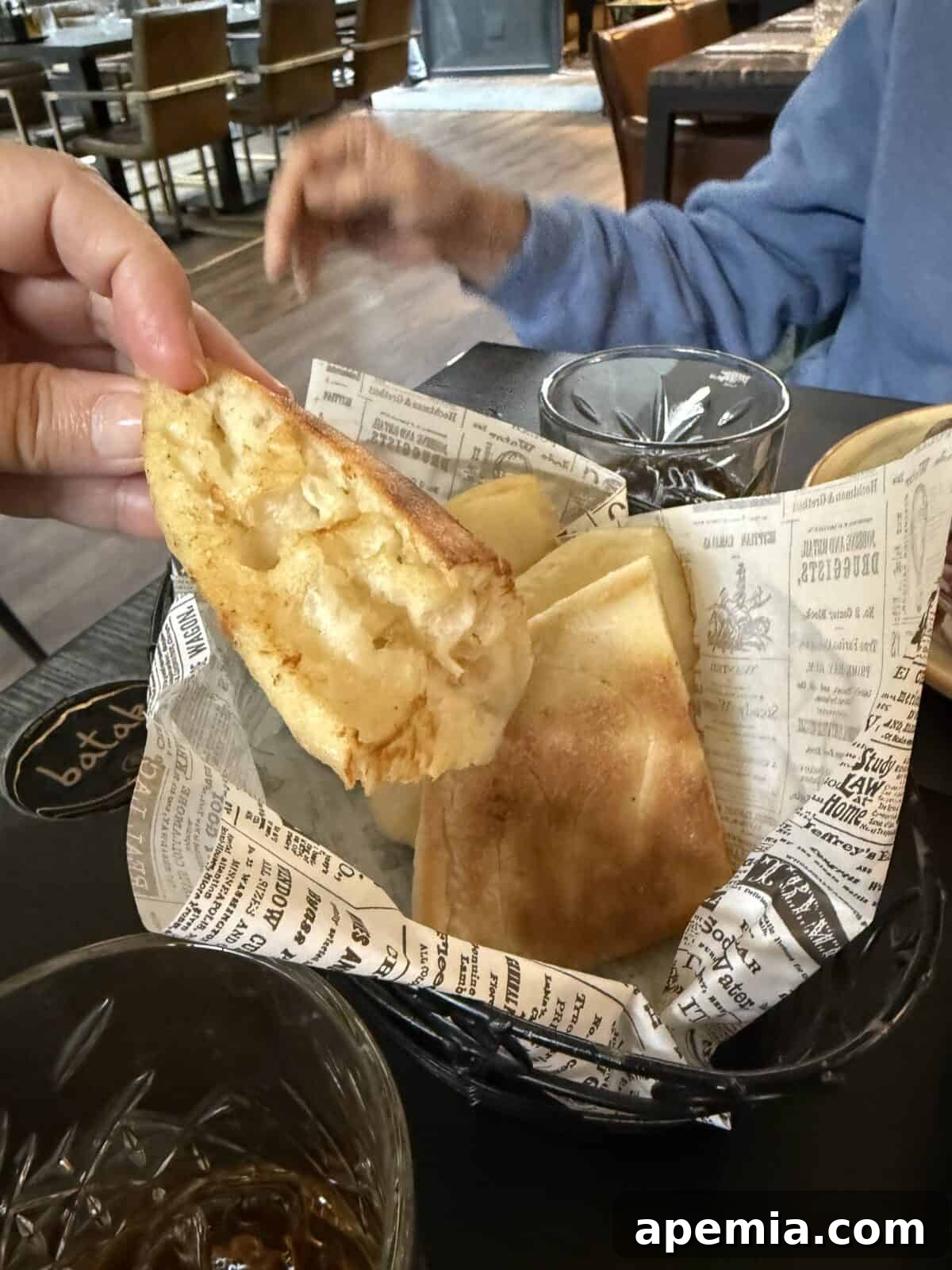 Classic Balkan Flatbread Lepinja 19 hand holding a piece of bread over bread basket