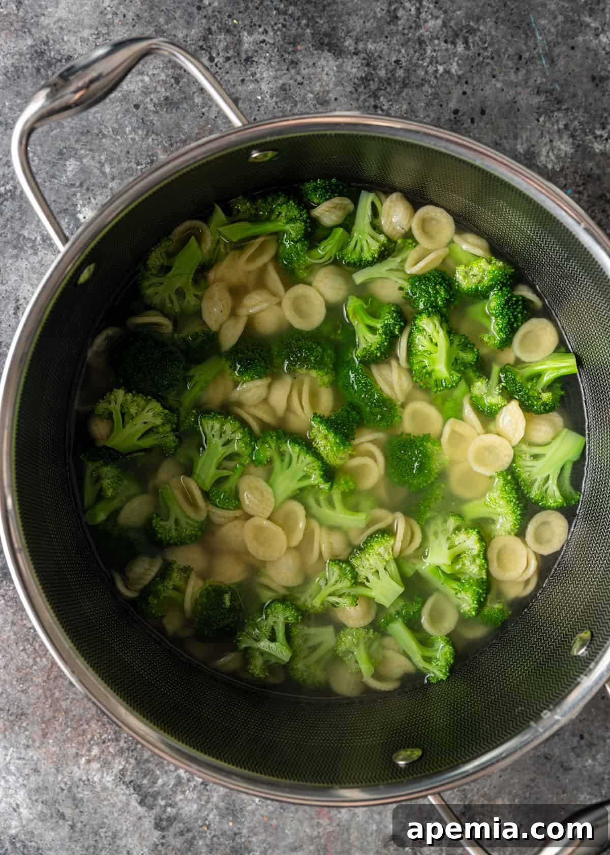 overhead process shot: boiled water with pasta and broccoli