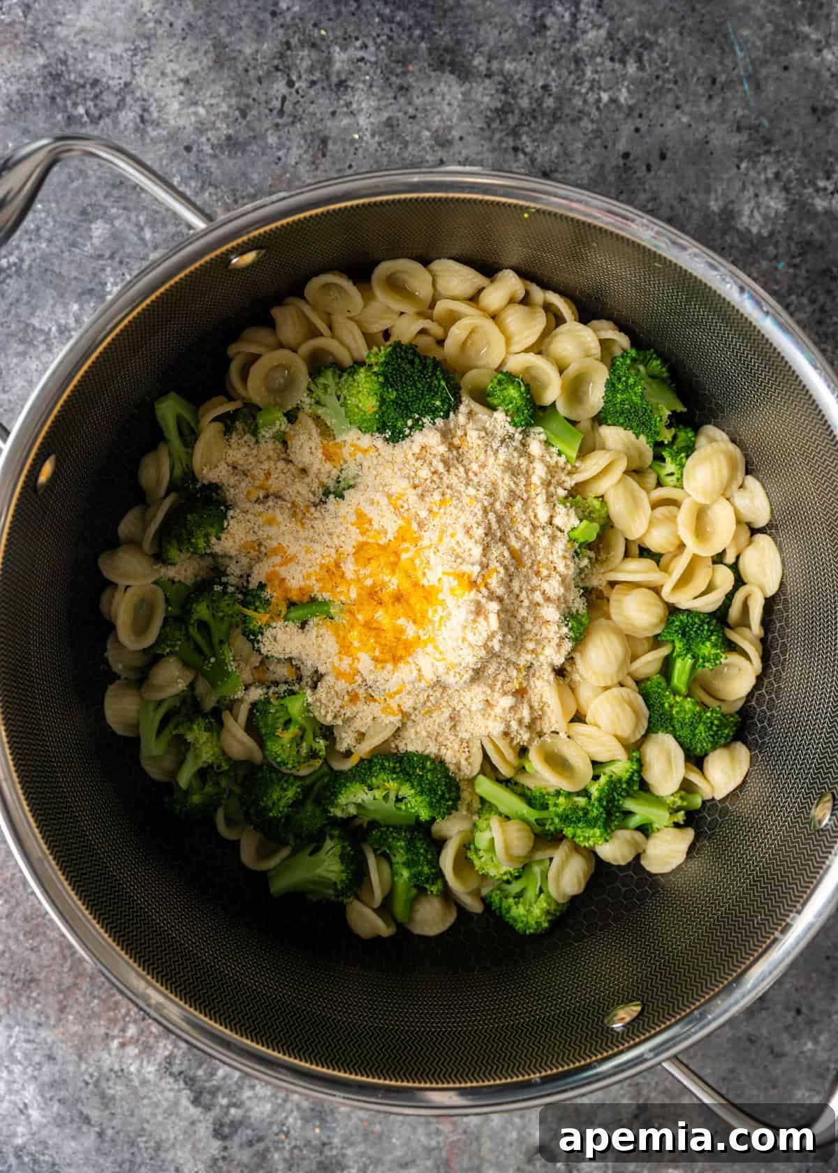 overhead process shot: topping ingredients (breadcrumbs, olive oil, parsley, salt and red pepper flakes) added to pasta and broccoli
