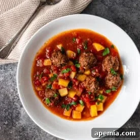A hearty bowl of Ras Asfour Meatball Stew, garnished and ready to be served, showcasing its vibrant colors and rich texture.