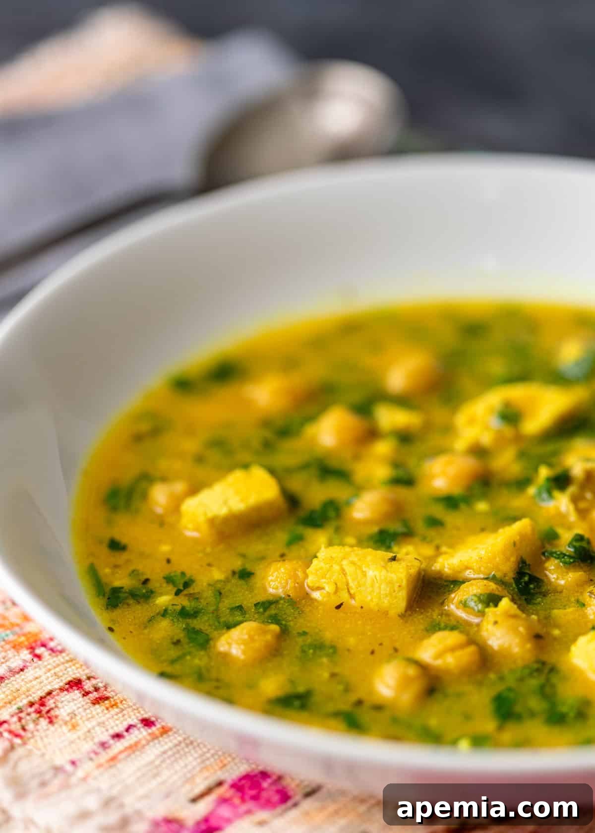 A close-up side view of a bowl of Hssoua, showing the creamy texture and chickpeas.