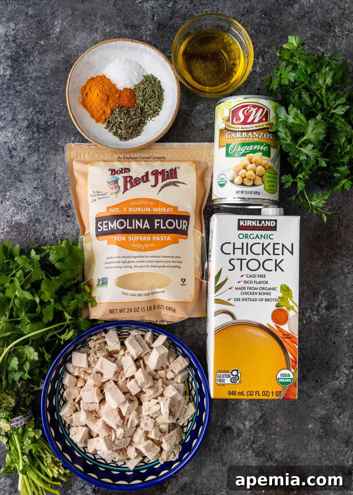 Overhead view of all the ingredients for the semolina soup recipe, laid out on a surface.