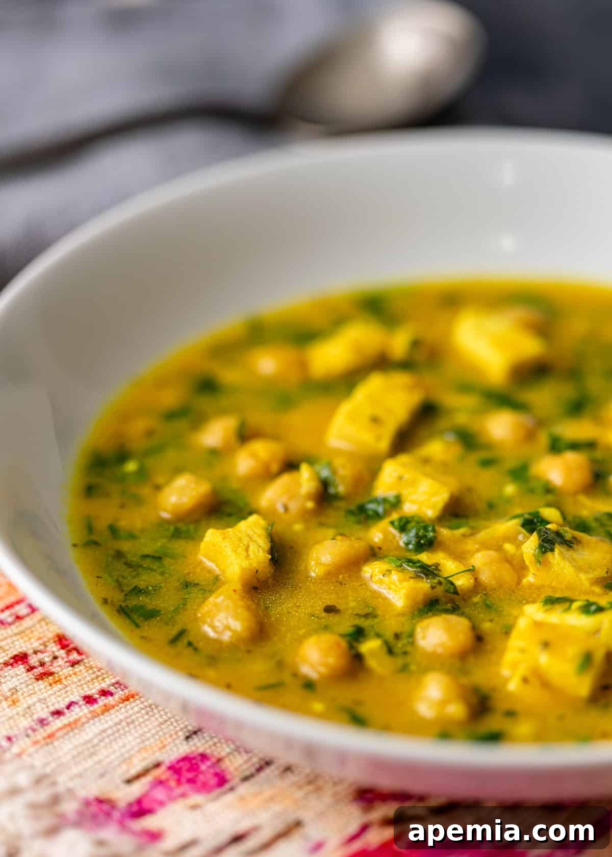 A side-angle, close-up shot of a spoon dipping into a bowl of creamy Moroccan Hssoua.