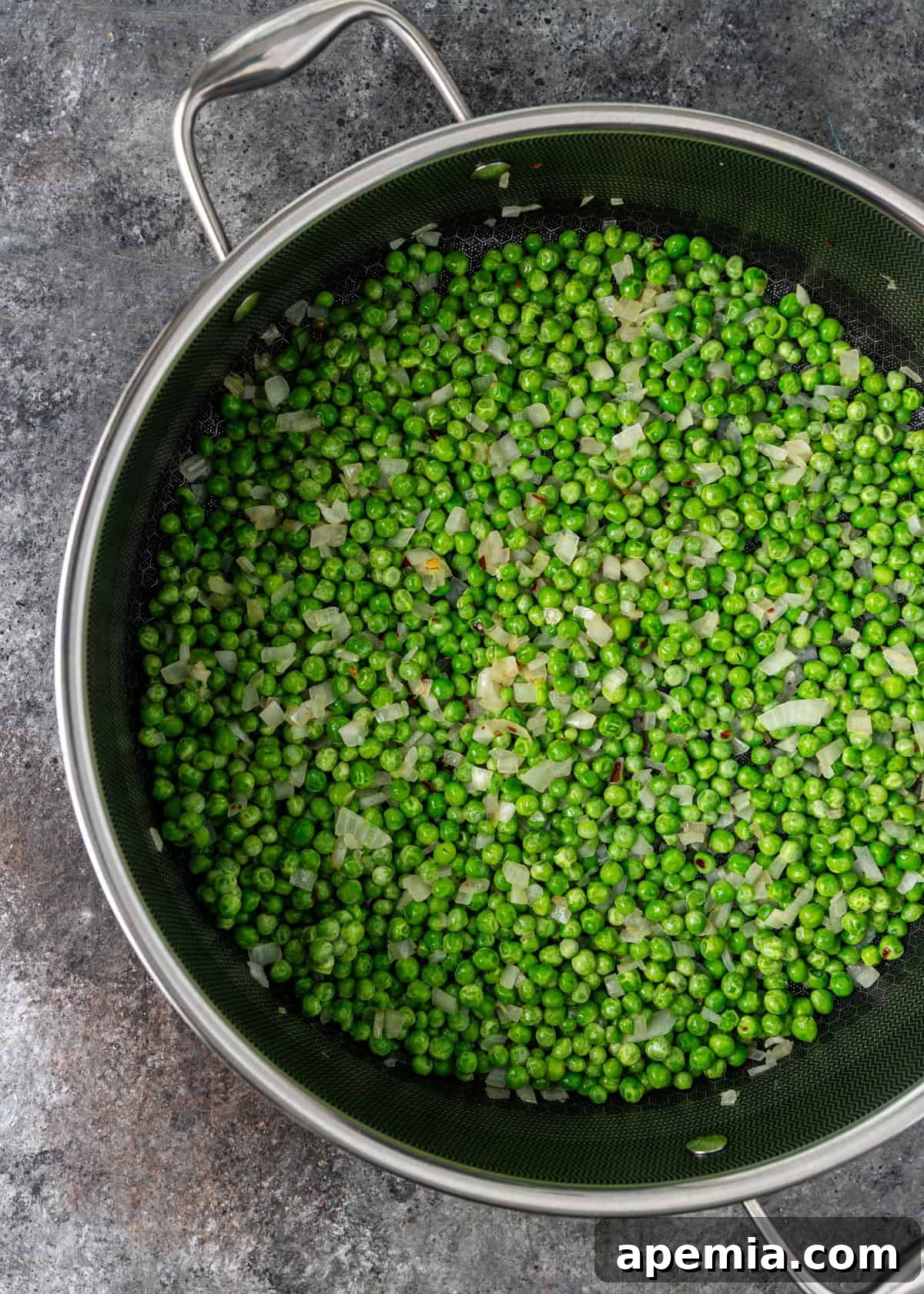 overhead process shot: peas, onions, and seasoning cooking in pot