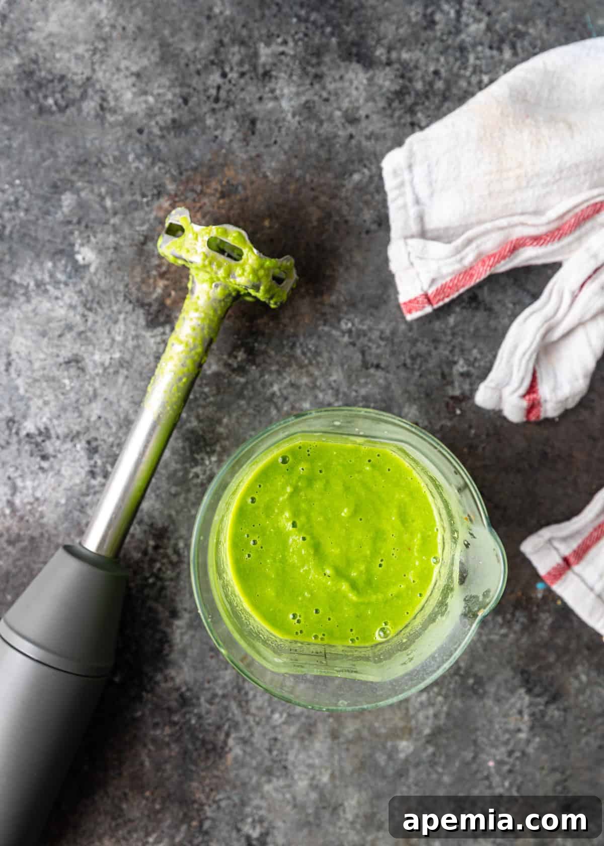 overhead process shot: measuring cup of blended peas with blender on side with blended peas on it