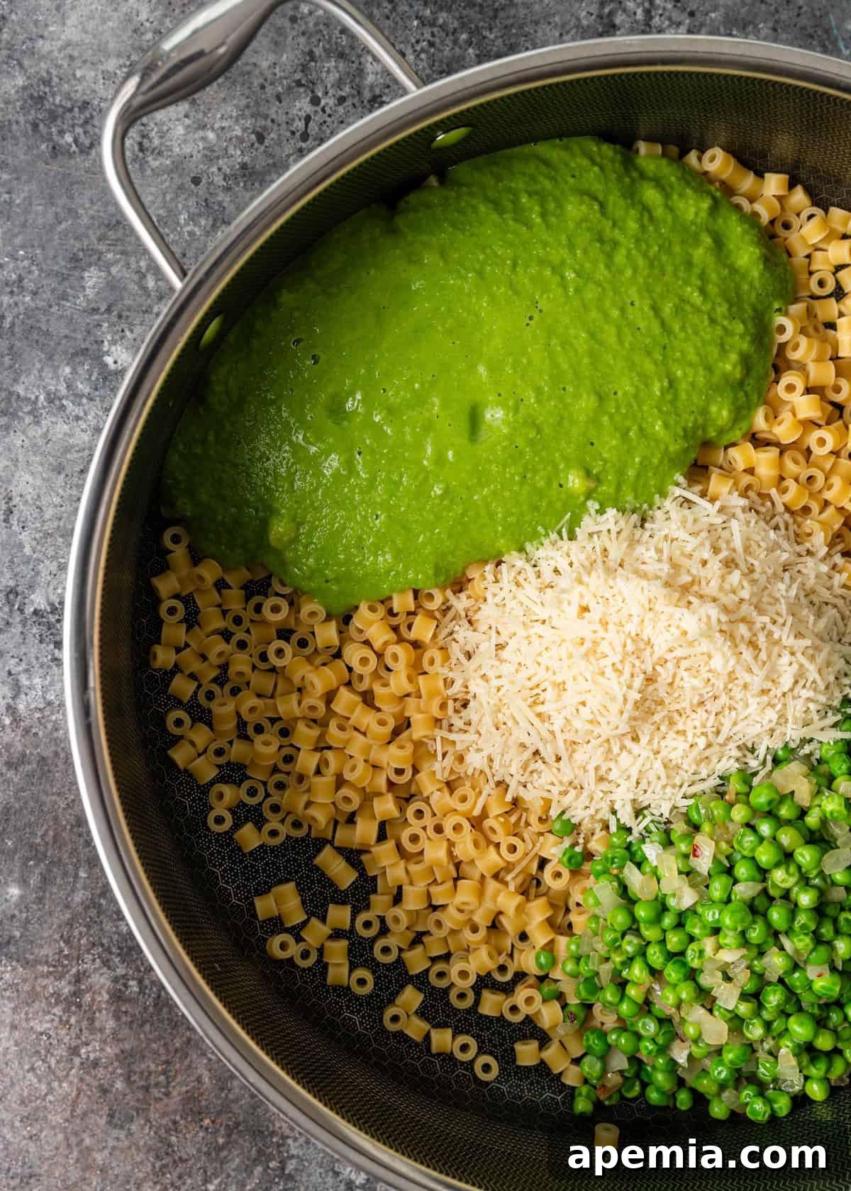 overhead process shot: cooked pasta, blended peas, parmesan cheese, and peas with onions in pot