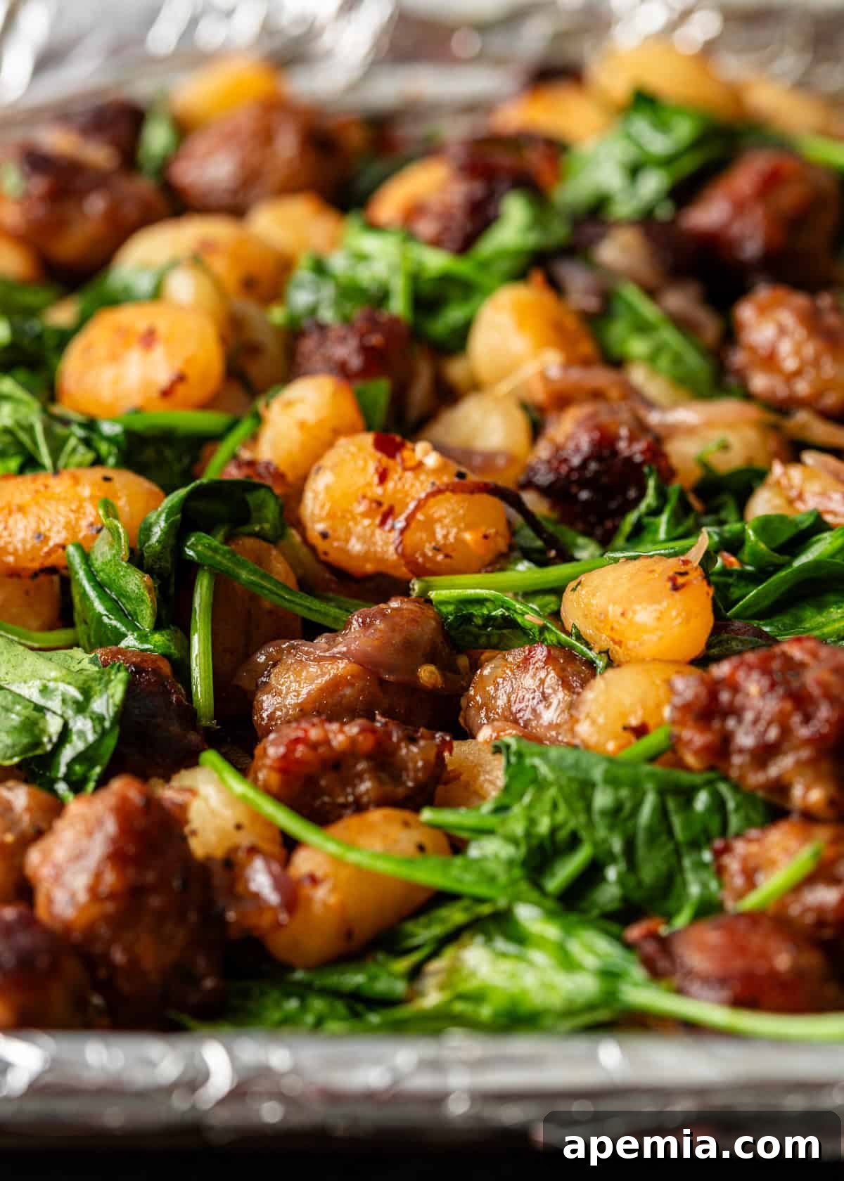 closeup side view: baked gnocchi on prepared baking sheet