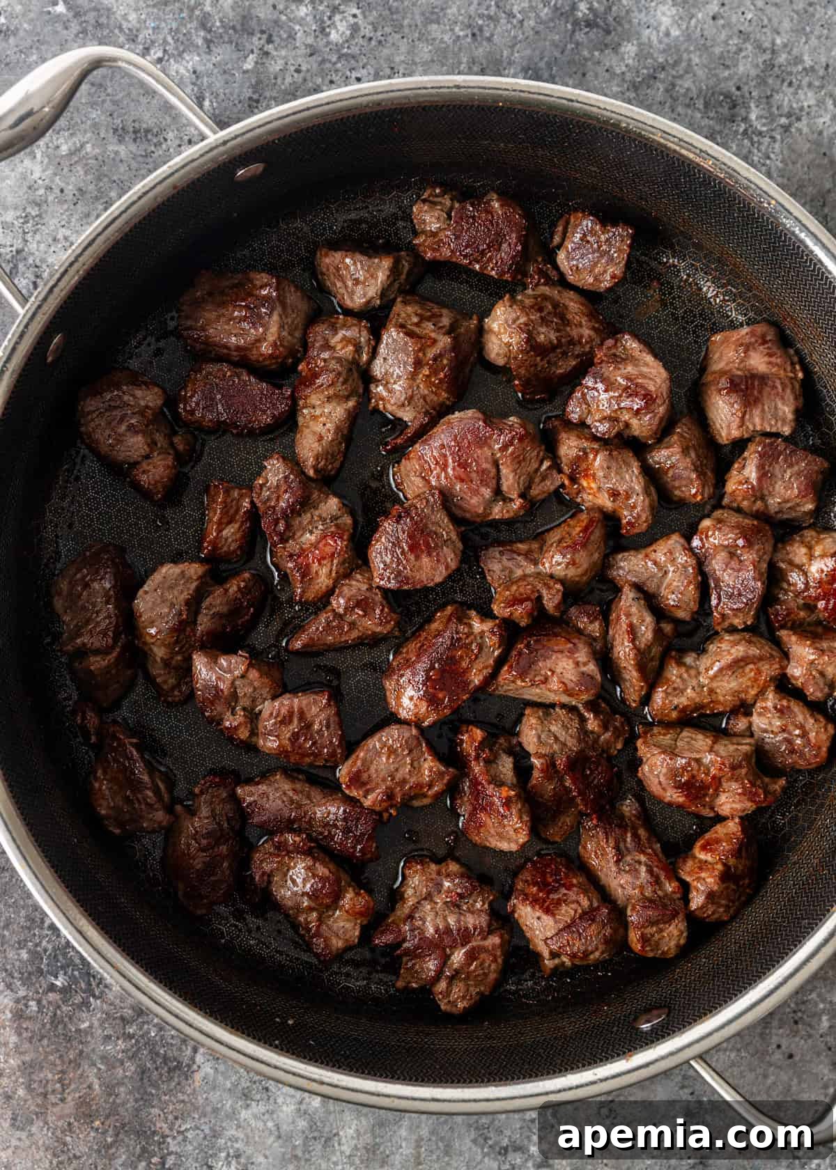 overhead process shot: cut lamb seasoned with salt and pepper, seared it in a Dutch oven 