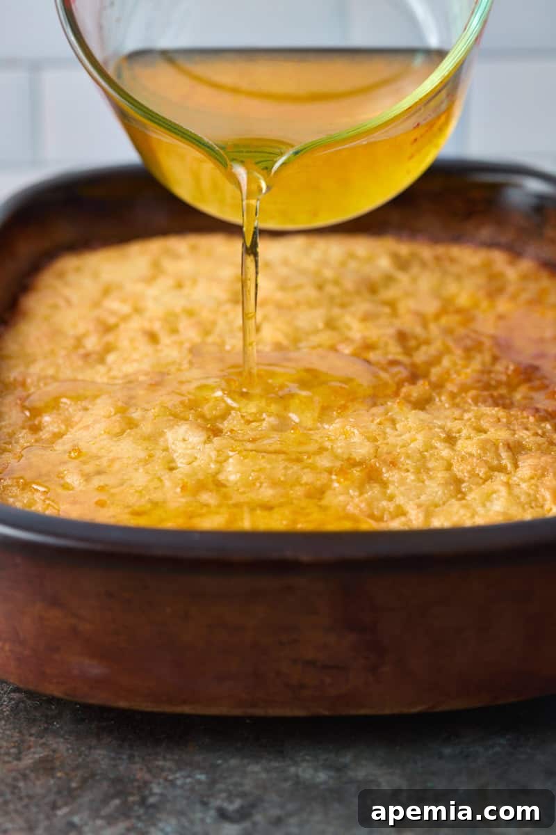 closeup side view: measuring cup of syrup being poured over the hot cake