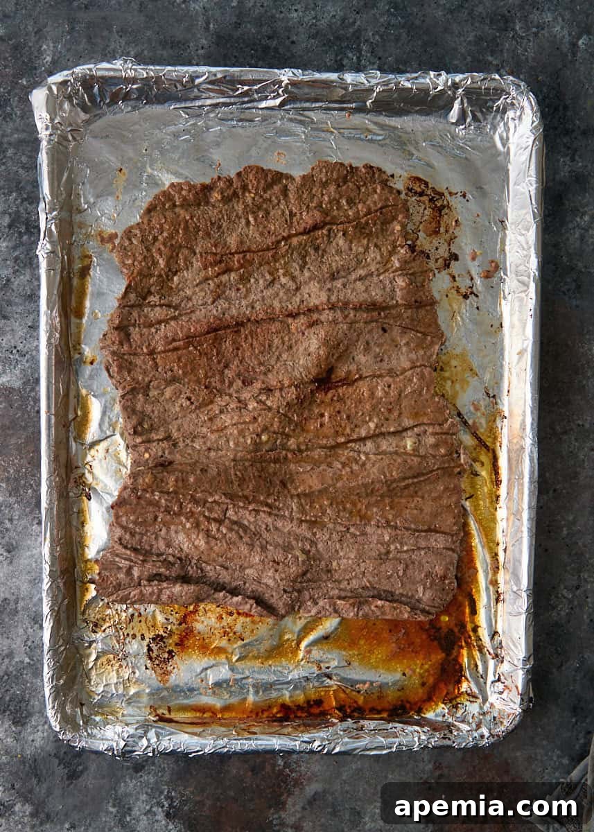 overhead process shot: cooked meat on foil on sheet pan
