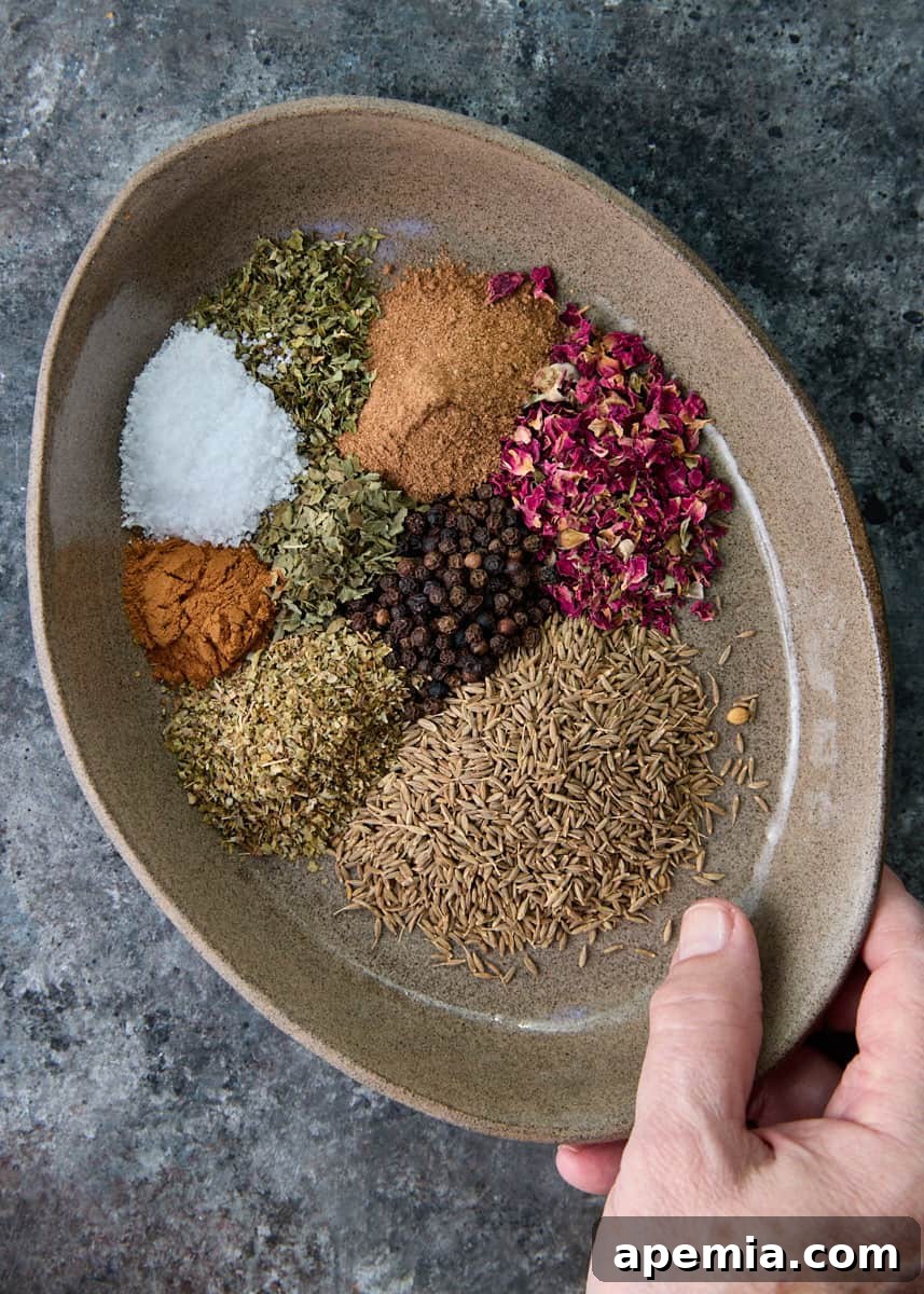 overhead: hand holding platter of spices to make this kamouneh recipe