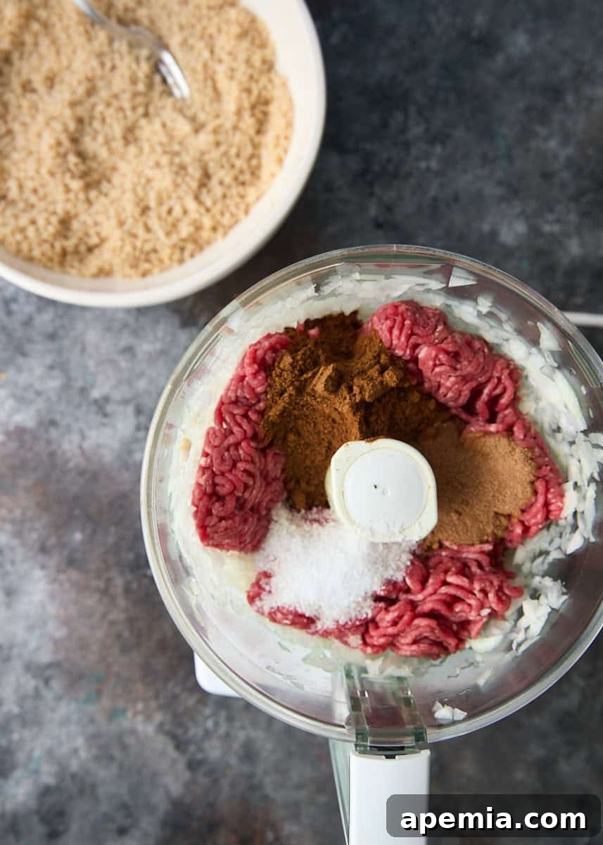 closeup overhead: ground beef mixture with kibbeh seasoning in blender