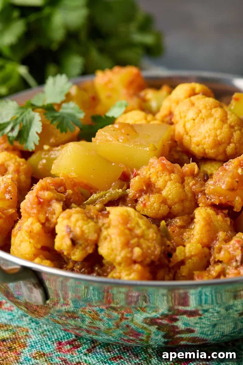 closeup side view: potato cauliflower curry in silver bowl
