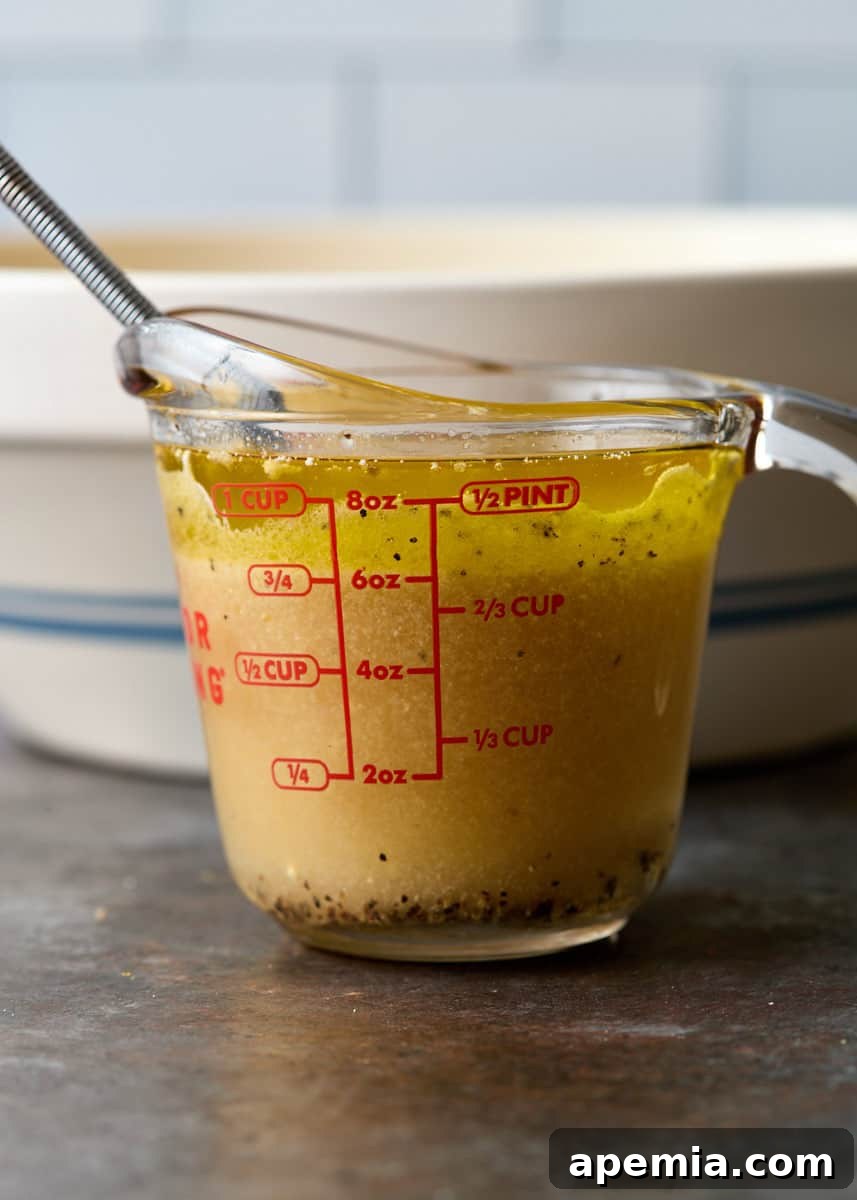 side view process shot: measuring cup with ingredients for dressing